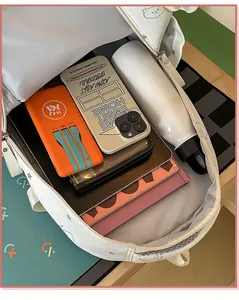 Vista detallada del interior de una mochila blanca de gran capacidad con útiles escolares