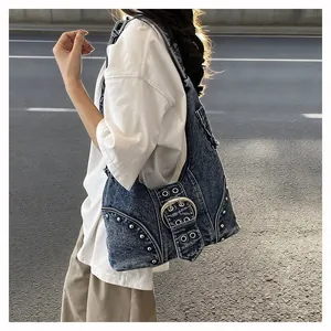 Detail of retro denim shoulder bag with heavy metal buckle and silver studs trim