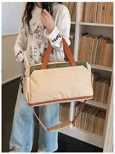 Grand sac de voyage de fitness beige et orange porté par un mannequin.