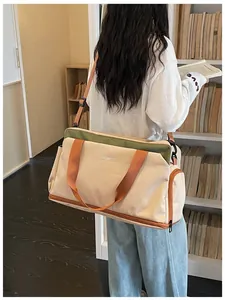 Grand sac de sport beige avec séparation sec-humide porté dans une salle d'étude.