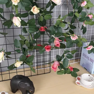 Vista detallada de enredaderas de rosas artificiales rosas y crema colgadas en rejilla
