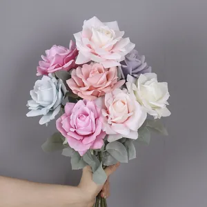 Dettaglio in primo piano di rose artificiali con petali strutturati e foglie verdi realistiche.