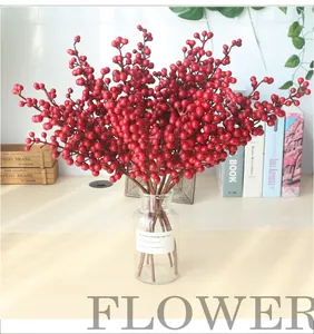 Close-up of artificial red berry branches in a clear glass vase for home decor