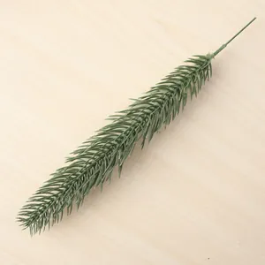 Close-up detail of a realistic green artificial pine branch for DIY home decor crafts.