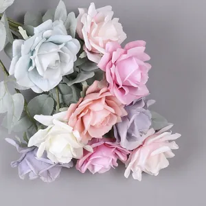 Primo piano dettagliato di un bouquet di rose artificiali colorate con foglie.