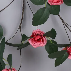 Vista detallada de la decoración de guirnalda de rosa rosa artificial con hojas verdes