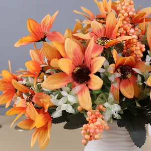 Close-up detail of vibrant orange artificial gerbera daisies with berry accents in a vase