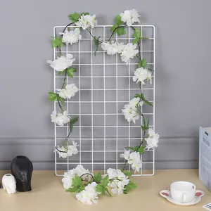 Vue détaillée d'une guirlande de fleurs de cerisier blanches de 2m sur grille blanche