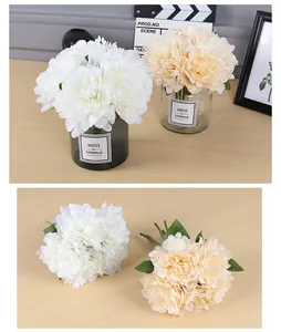 Vista detallada de ramos de peonías artificiales blancos y crema para decoración