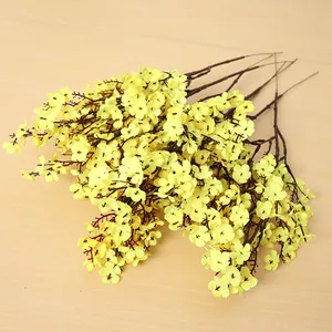 Detalle de ramas de paniculata amarilla de seda sobre fondo de madera.