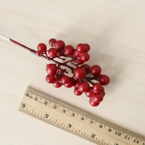 Gros plan de baies rouges artificielles avec une règle pour référence de taille.