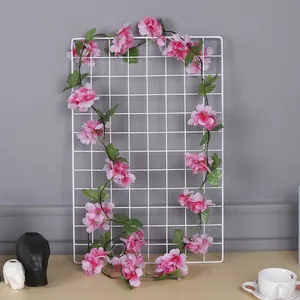 Vue détaillée d'une guirlande de fleurs de cerisier artificielles roses de 2m sur une grille