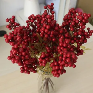 Künstlicher roter Beerenstiel für die Weihnachtsdekoration in einer Glasvase