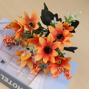 Close-up of orange artificial daisy bouquet on a book, table decor