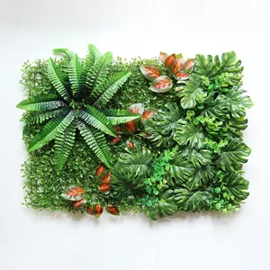 Detailopname van een kunstmatige plantenwand met groene varen- en monstera-bladeren