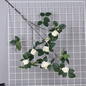 Vista detallada de una guirnalda de rosas blancas artificiales sobre una rejilla metálica blanca