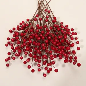 Gros plan de baies de houx artificielles rouges pour décorations festives de Noël et fêtes