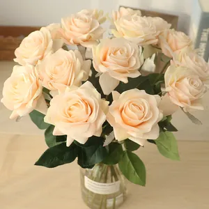 Gros plan d'élégantes roses artificielles crème dans un vase en verre pour mariage