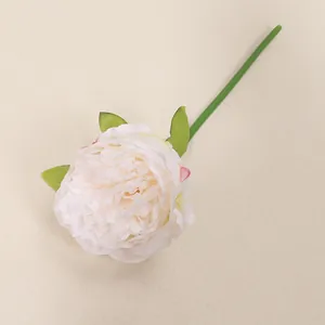 Close-up view of a single cream white artificial peony flower with green leaves and stem