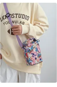 Detalle de cerca de un bolso cruzado para móvil con estampado de mariposas en modelo