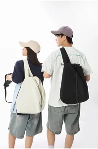 Detailed view of large nylon tote bags worn by a couple in a minimalist style.