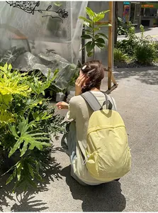Lifestyle shot of a lightweight yellow minimalist backpack for student daily use and travel