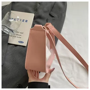 Détail de profil d'un sac à bandoulière en PVC transparent rose avec sangle