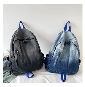 Close-up view of two retro washed denim backpacks in black and blue gradient finishes