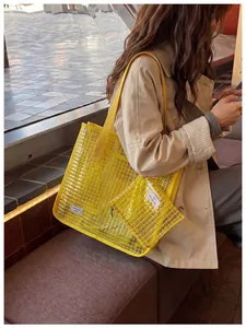 Borsa tote in PVC giallo trasparente con pochette abbinata indossata da una modella