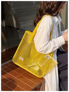 Primo piano della borsa tote gialla in PVC a griglia con pochette coordinata