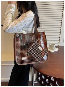 Dettaglio lifestyle della borsa tote a griglia in PVC marrone e pochette coordinata.