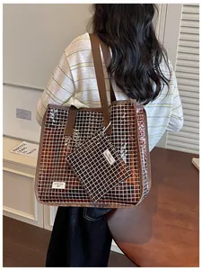 Dettaglio di una borsa shopping in PVC marrone a quadretti con astuccio coordinato