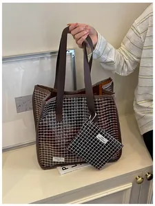 Vista dettagliata della borsa tote in PVC a quadri marrone scuro con pochette