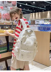 Chica con mochila blanca de ositos en un supermercado, vista detallada del producto