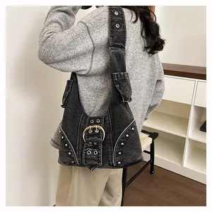 Close-up detail of a vintage black denim hobo bag featuring silver rivets and metal buckle