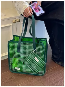 Primo piano di borsa tote in rete verde traslucida con pochette per il pendolarismo quotidiano.
