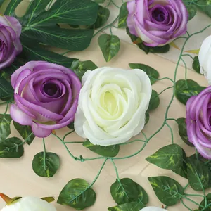 Dettaglio ravvicinato di teste di rose artificiali viola e bianche con foglie