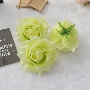 Detailed view of light green artificial silk rose flower heads for wedding decor