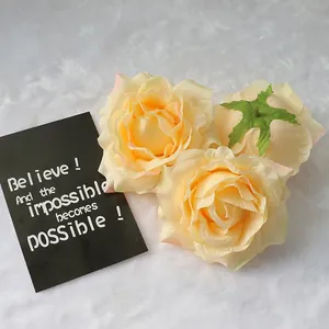 Detailed view of three champagne artificial silk rose heads for wedding decorations