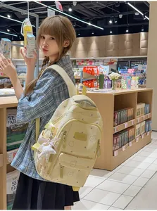 Una mochila escolar amarilla con lindos estampados de osos usada por una chica en una tienda