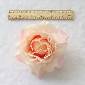 Detail view of artificial silk rose flower head with ruler for size reference