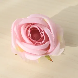 Vista macro dettagliata di una testa di rosa artificiale rosa su un tavolo di legno chiaro