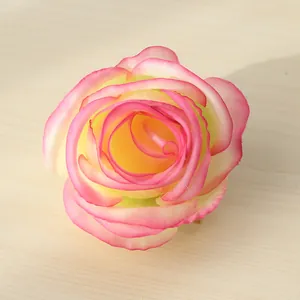 Primo piano di una testa di rosa artificiale in seta rosa e crema con bordi arricciati