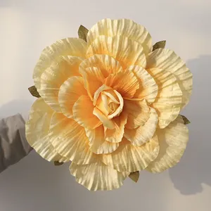Macro view showing the realistic crepe paper texture of a large yellow artificial rose.