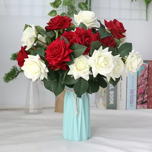 Artificial red and white velvet rose bouquet in light blue ceramic vase.
