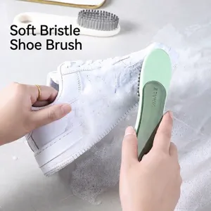 Soft bristled cleaning brush for shoes and clothes with dense foam on a sneaker
