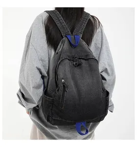 Back view of a distressed vintage washed denim backpack with blue strap accents