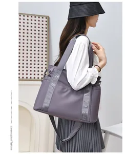 Borsa da viaggio viola capiente portata da una modella, ideale per viaggi brevi.