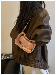 Vue détaillée d'un sac à aisselle rose transparent en PVC porté sur une veste en cuir
