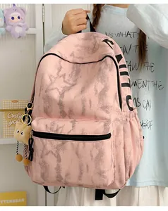 Detail des rosa Rucksacks mit Marmormuster, großem schwarzem Schriftzug und Anhänger.